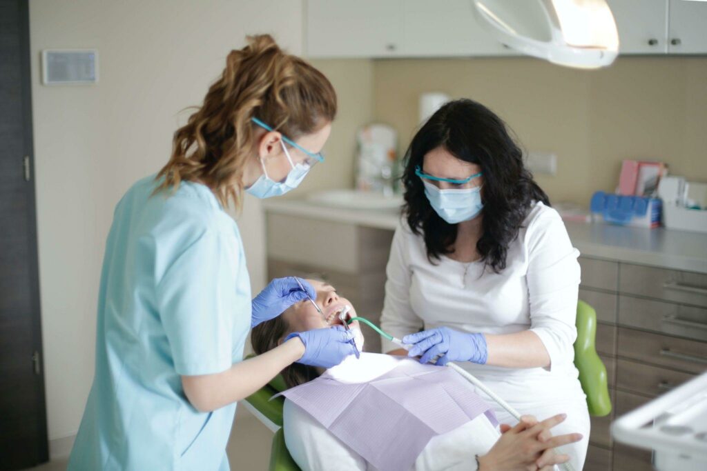 a dentist and a dental assistant performing dental cleaning