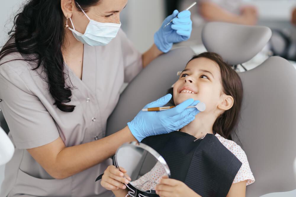 a smiling little girl on a dental chair