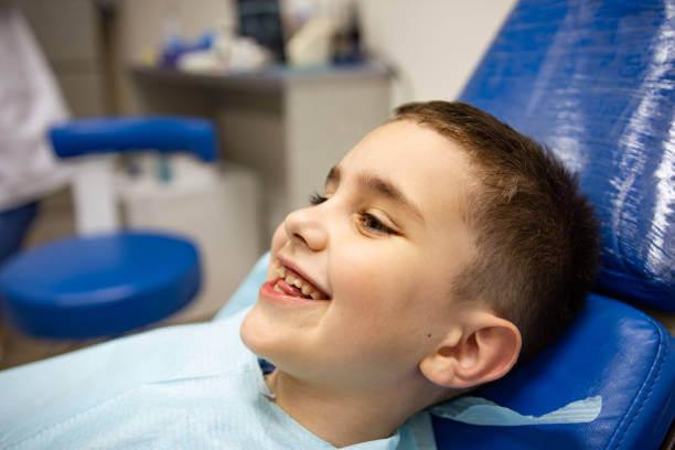 a smiling young boy on a dentist chair