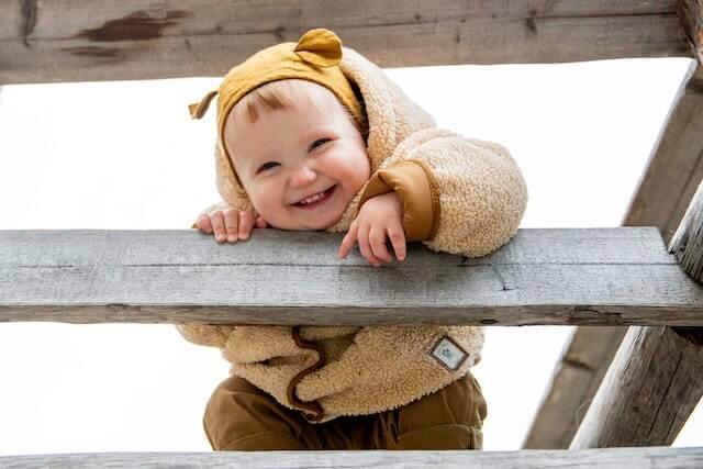 a smiling baby in a fuzzy jacket