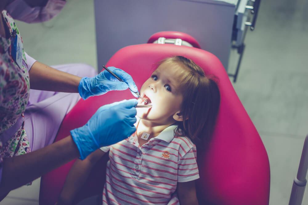 a little girl on a dentist chair getting dental check-up