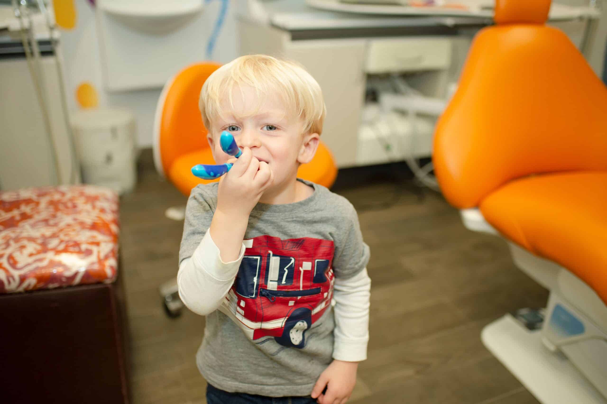 Child holding a blue teething toy in the treatment room