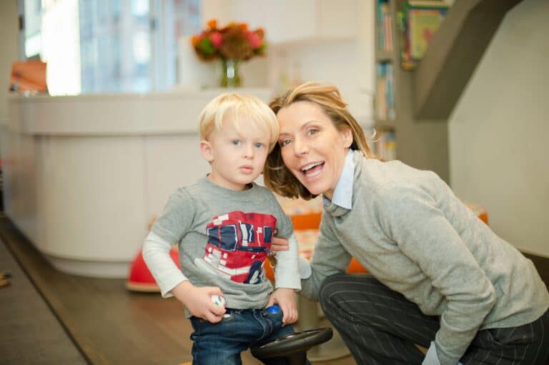 Dentist beside a young boy in the reception play area
