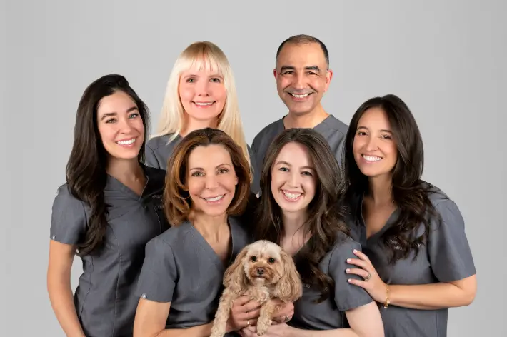 Bright Healthy Smiles team of six in gray scrubs with the office dog