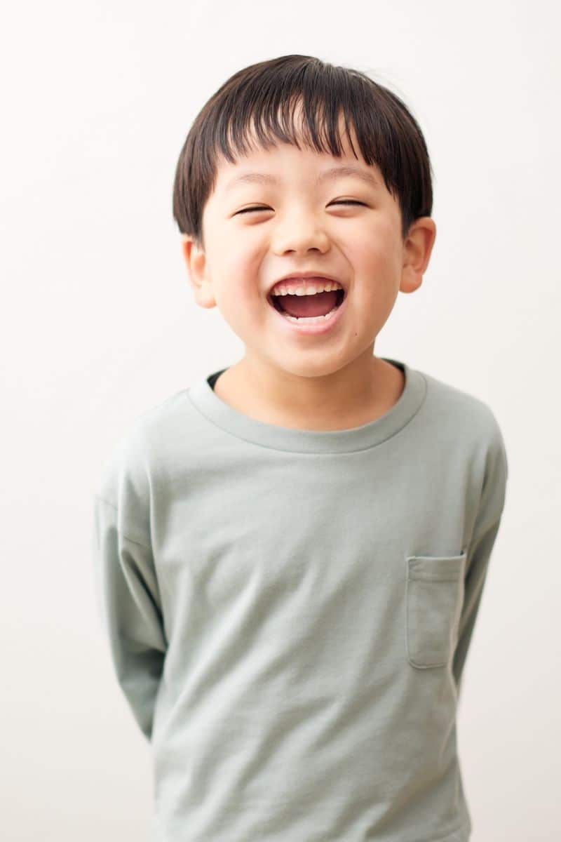 Smiling boy after tooth-colored children's dental fillings at our Upper East Side office. Young boy laughing during an Invisalign for kids consultation at our NYC orthodontic office.