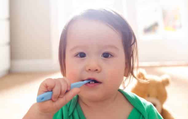a baby brushing his teeth