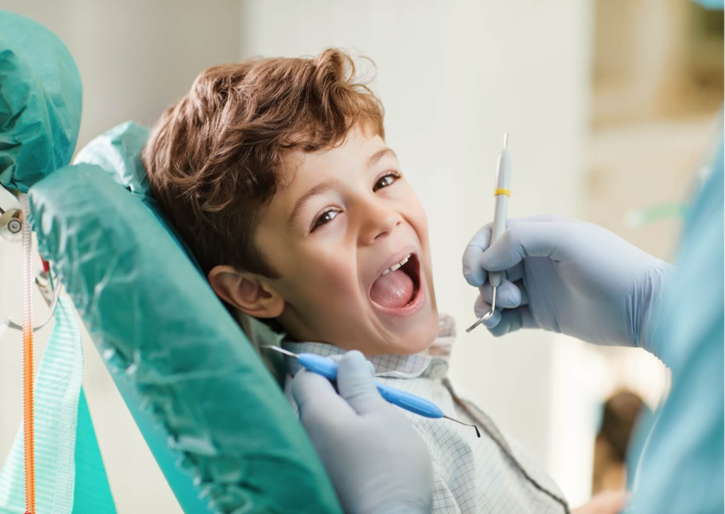 Young child receiving a dental exam during a visit for protective dental sealants on permanent molars.