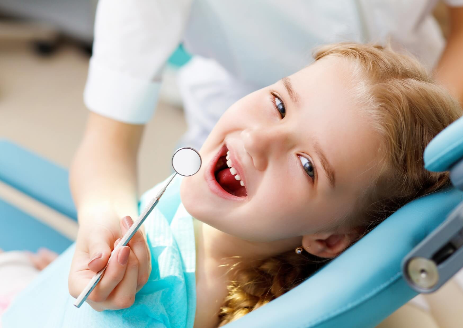 Young child receiving a dental exam before placement of a pediatric dental spacer to preserve space for permanent teeth.