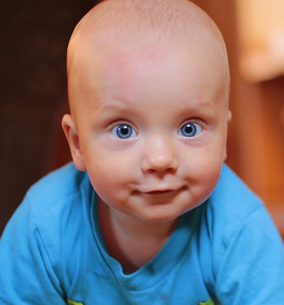 a photo of a baby in blue directly looking at the camera