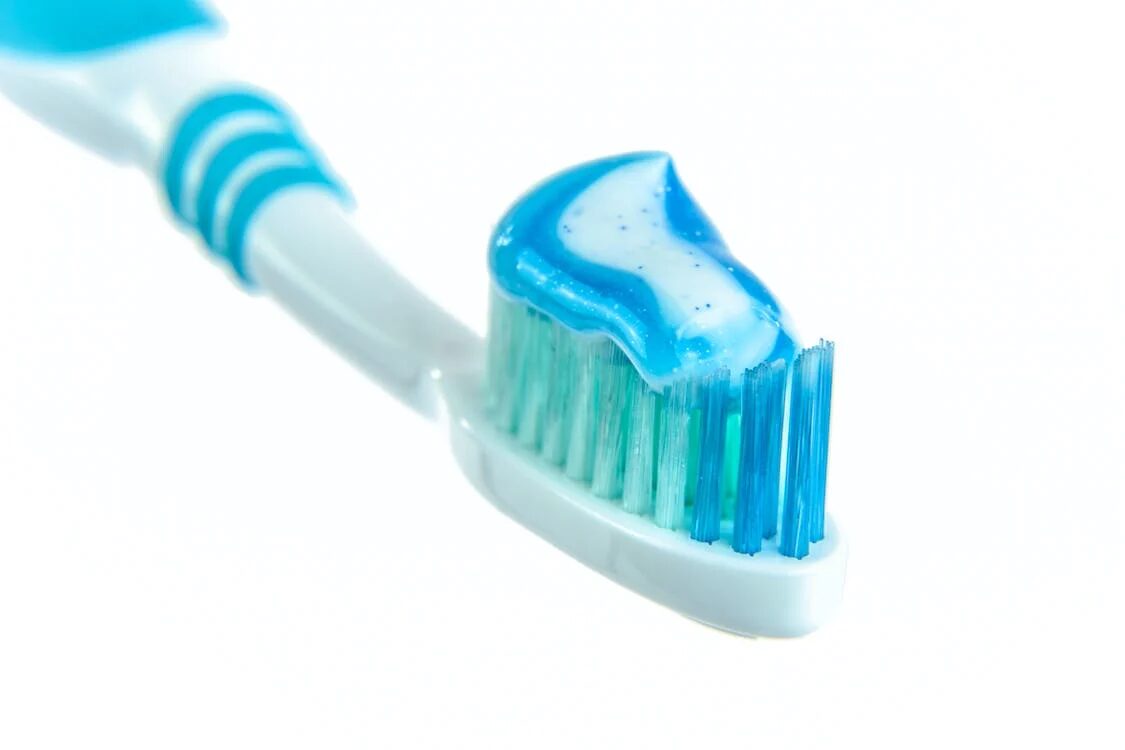 a blue toothpaste on a blue and white toothbrush